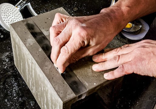 Abschleifen einer Feinbetonfassung per Hand für eine Stilhandlampe des Modells Zebra